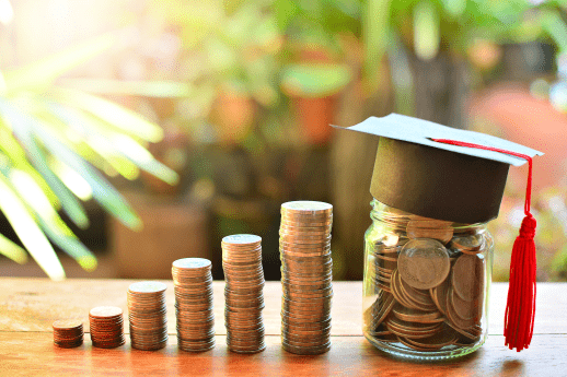 tuition money on table with a graduation cap