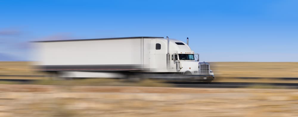 speeding white semi truck on the move