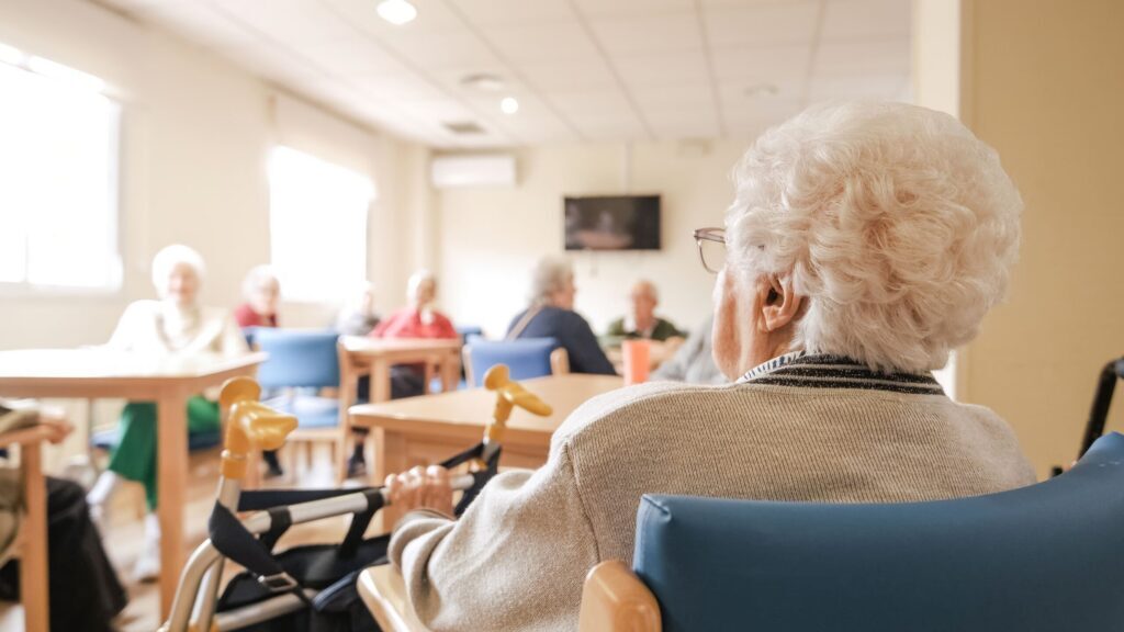 An elderly resident sitting with a walker in a care facility common area represented by St Louis nursing home abuse lawyers.