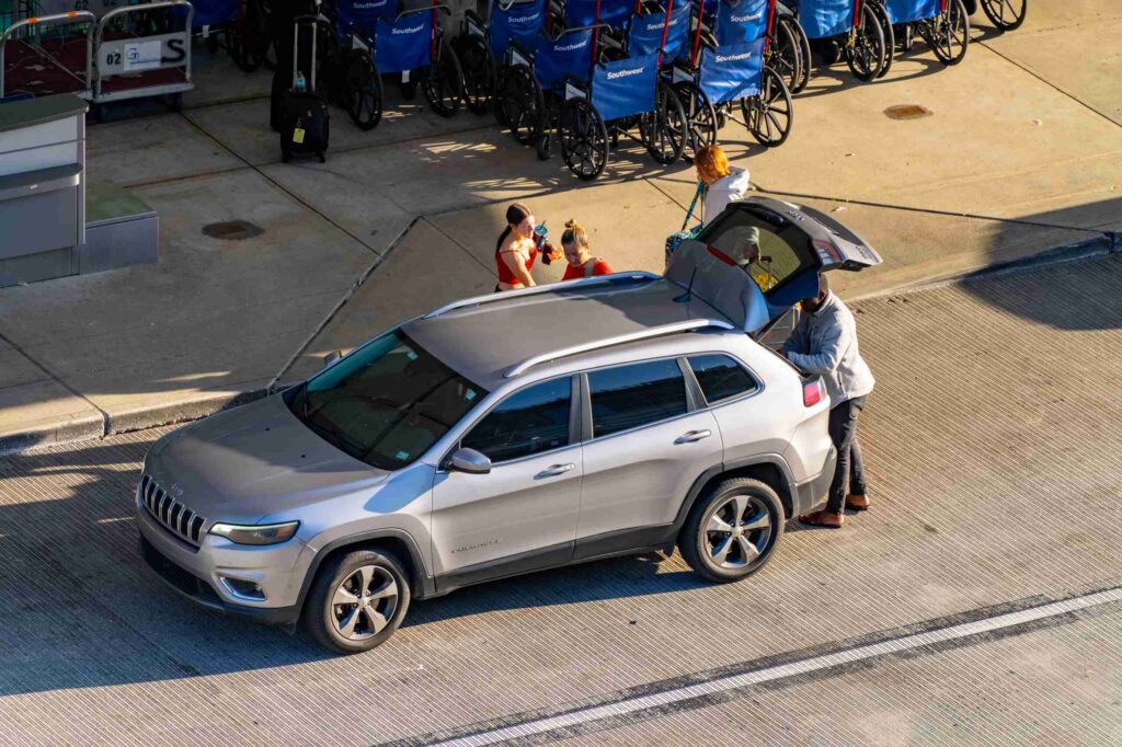 A rideshare driver helps passengers load luggage into an SUV trunk for St Louis Uber and Lyft accident lawyers